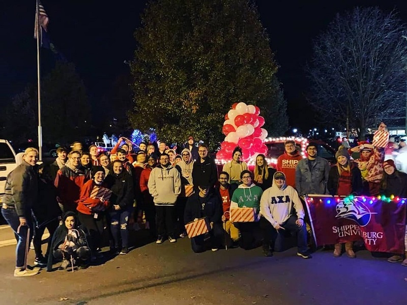 Ship students participate in community holiday parade and hand out treats to children. 